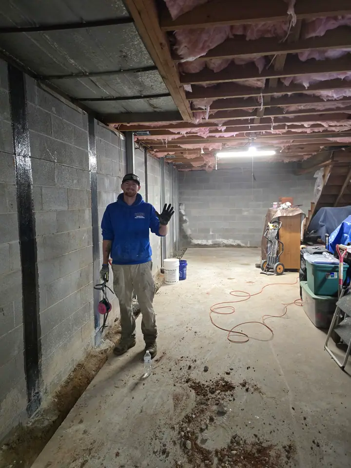 A Rozier Pest Control & Waterproofing technician installing an interior drainage system in a basement.