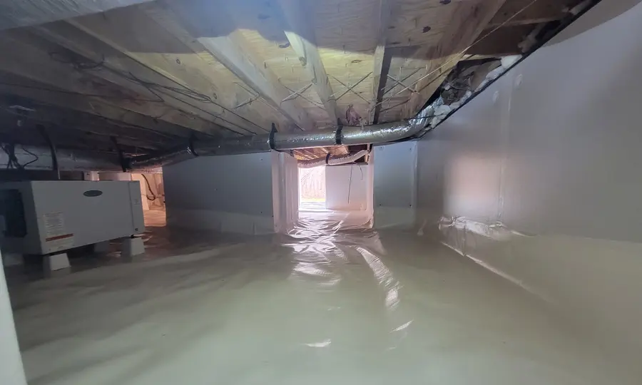 A crawl space vapor barrier and dehumidifier installed by Rozier Pest Control & Waterproofing for moisture control.