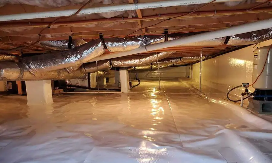 A clean white vapor barrier installed by Rozier Pest Control & Waterproofing across a crawl space floor beneath insulated ducts.