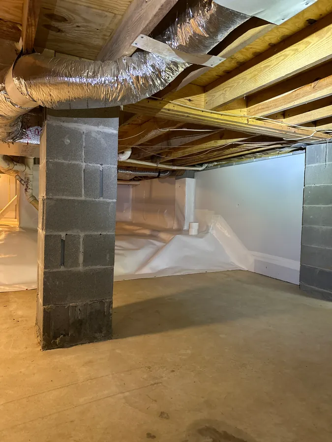 Rozier Pest Control & Waterproofing installing a clean crawl space vapor barrier.