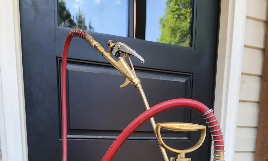 Rozier Pest Control & Waterproofing sprayer equipment at a residential front door before a perimeter treatment.