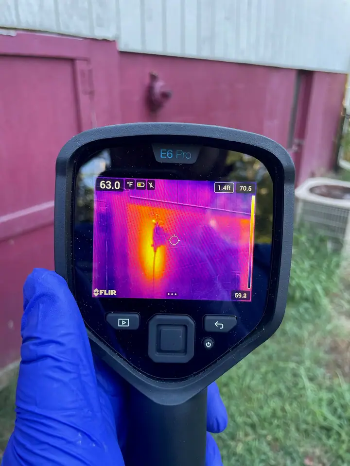 A Rozier Pest Control & Waterproofing technician using a thermal imaging camera for a detailed pest inspection.