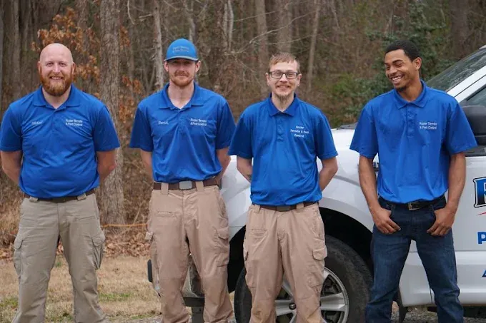 Four Rozier technicians in company polos standing in front of a service truck