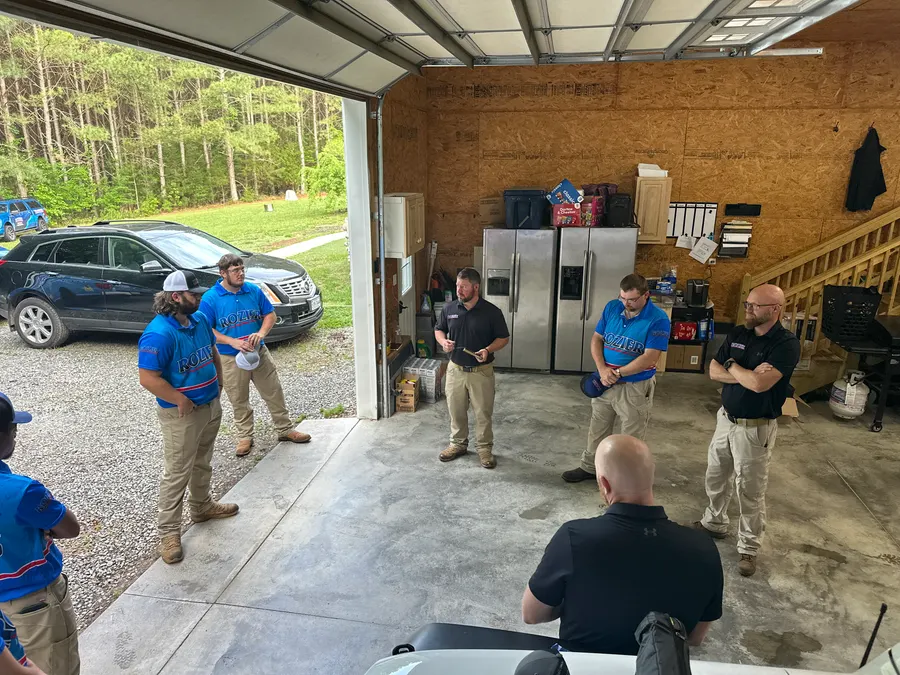 Rozier Pest Control & Waterproofing crew members at a company meeting in the shop.