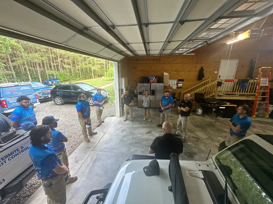 The Rozier Pest Control & Waterproofing crew gathered for a morning briefing in the company shop.