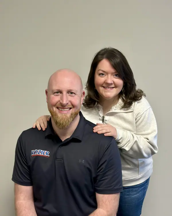 Two Rozier Pest Control & Waterproofing team members in a portrait at the office.