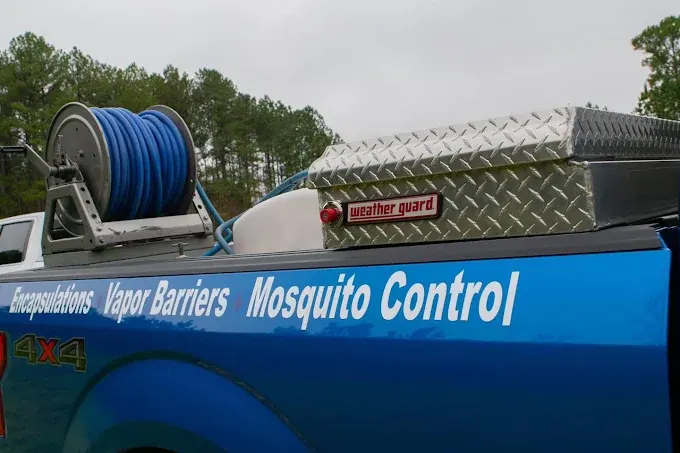 The hose reel and toolbox on the bed of a Rozier Pest Control & Waterproofing service truck.
