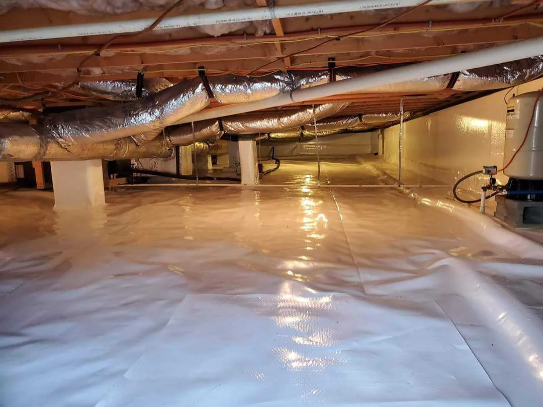 Rozier Pest Control & Waterproofing installing a clean crawl space vapor barrier for moisture control and encapsulation.