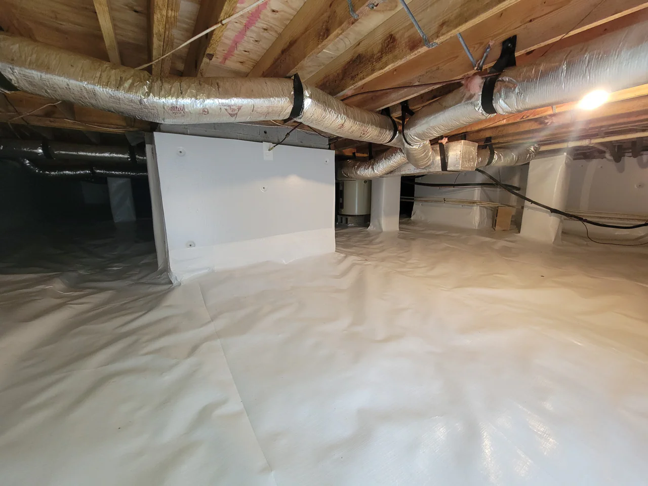 Rozier Pest Control & Waterproofing completed a full crawl space encapsulation with a bright white vapor barrier system.