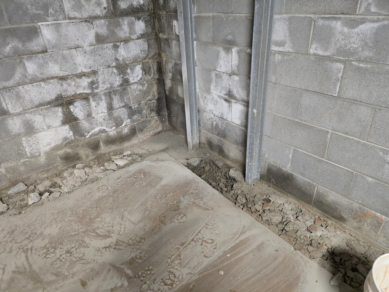 Rozier Pest Control & Waterproofing installing an interior drainage system for basement waterproofing, showing excavated trench